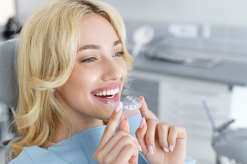 Photo young-attractive-woman-holding-invisible-braces