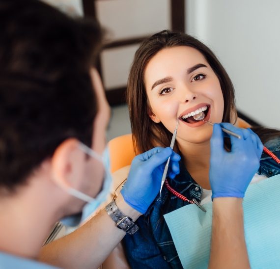 photo-back-professional-dentist-man-working-with-patient-modern-clinic